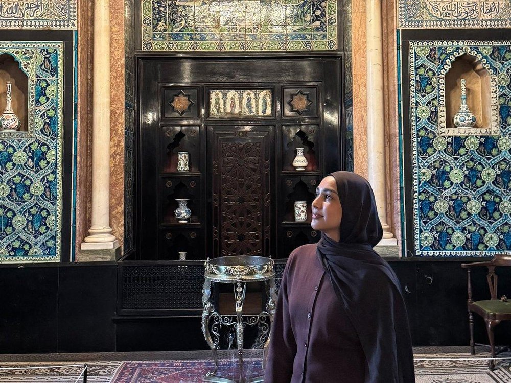 Lady with a headscarf with with a blue tiled background