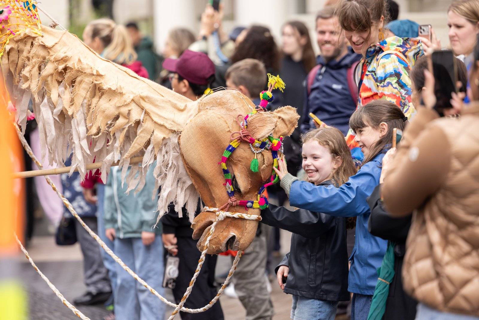 Serendipity Arts' Giants on the Move performance at the Great Exhibition Road Festival Children and festival visitors gather around a large handcrafted horse puppet decorated with colourful tassels during Serendipity Arts' Giants on the Move performance at the Great Exhibition Road Festival.